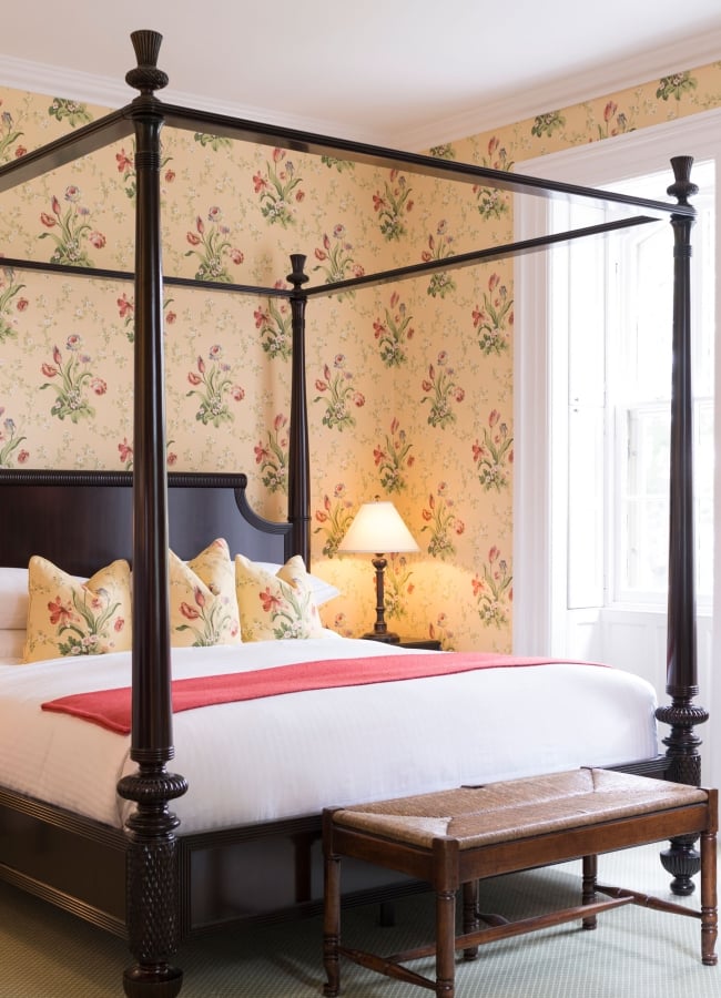 E.B. Morgan House Bedroom with floral wallpaper and four poster bed.
