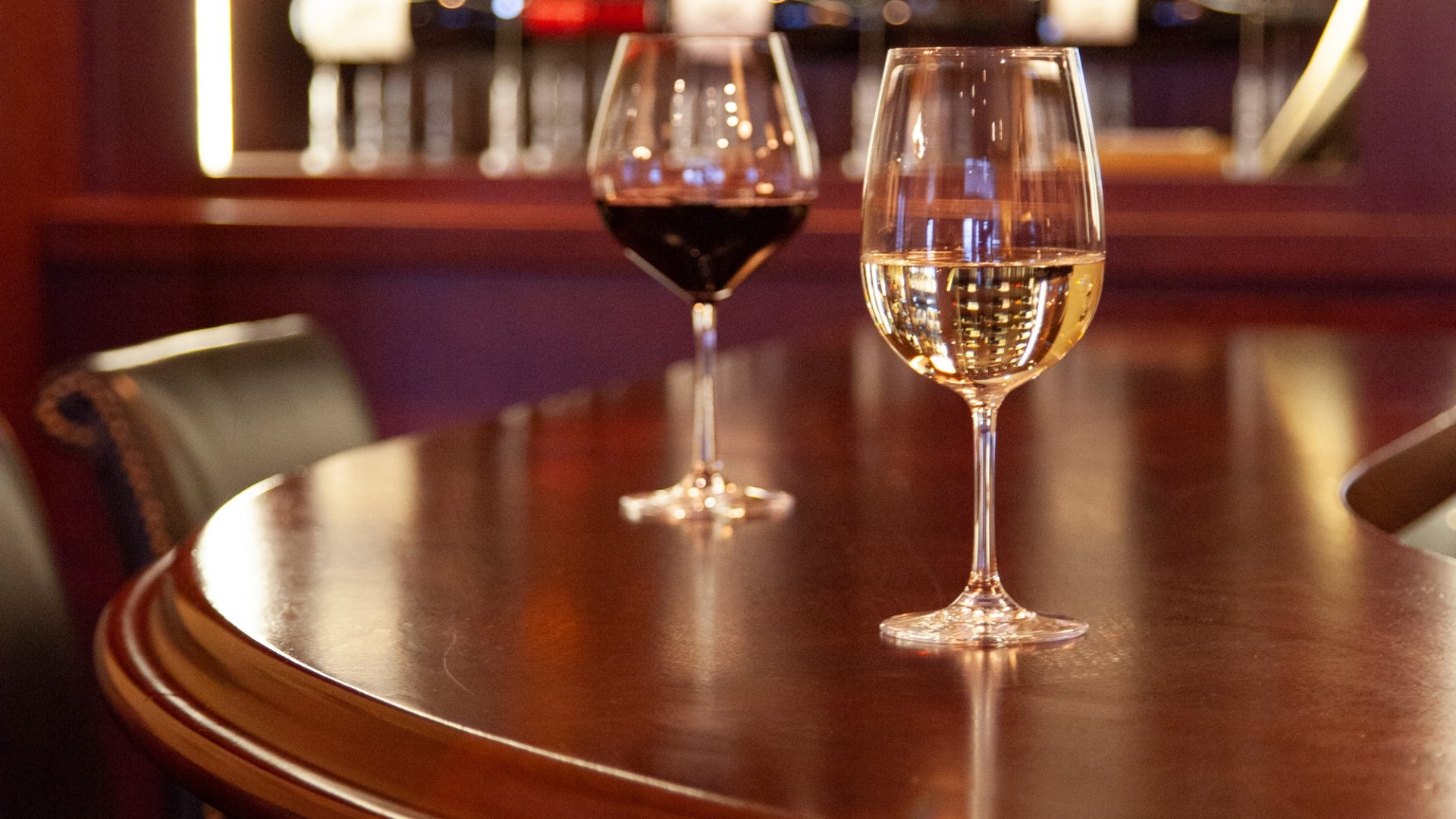 Two glasses of wine on round table at 1833 Kitchen & Bar.