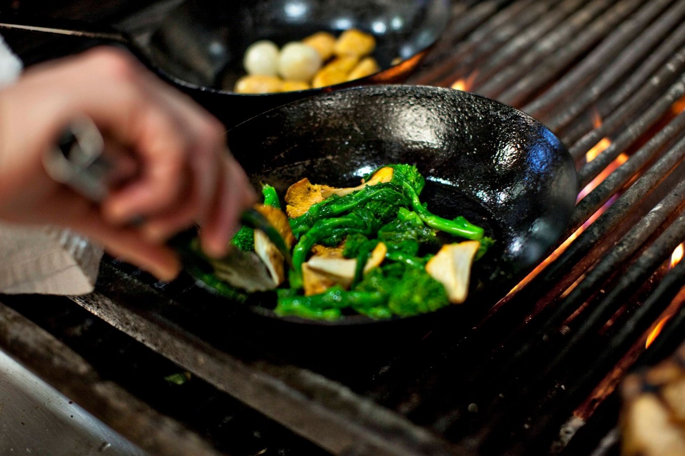 Preparing a meal on a grill, using a pan to cook