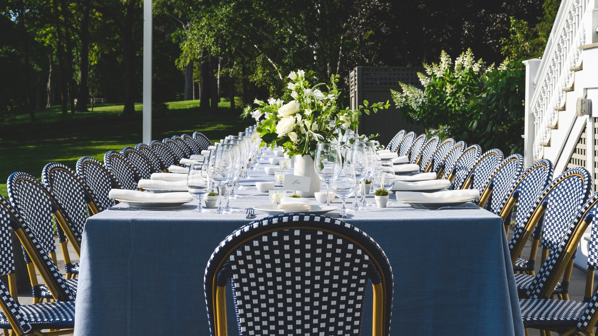 A blue table setup with for a rehearsal dinner.