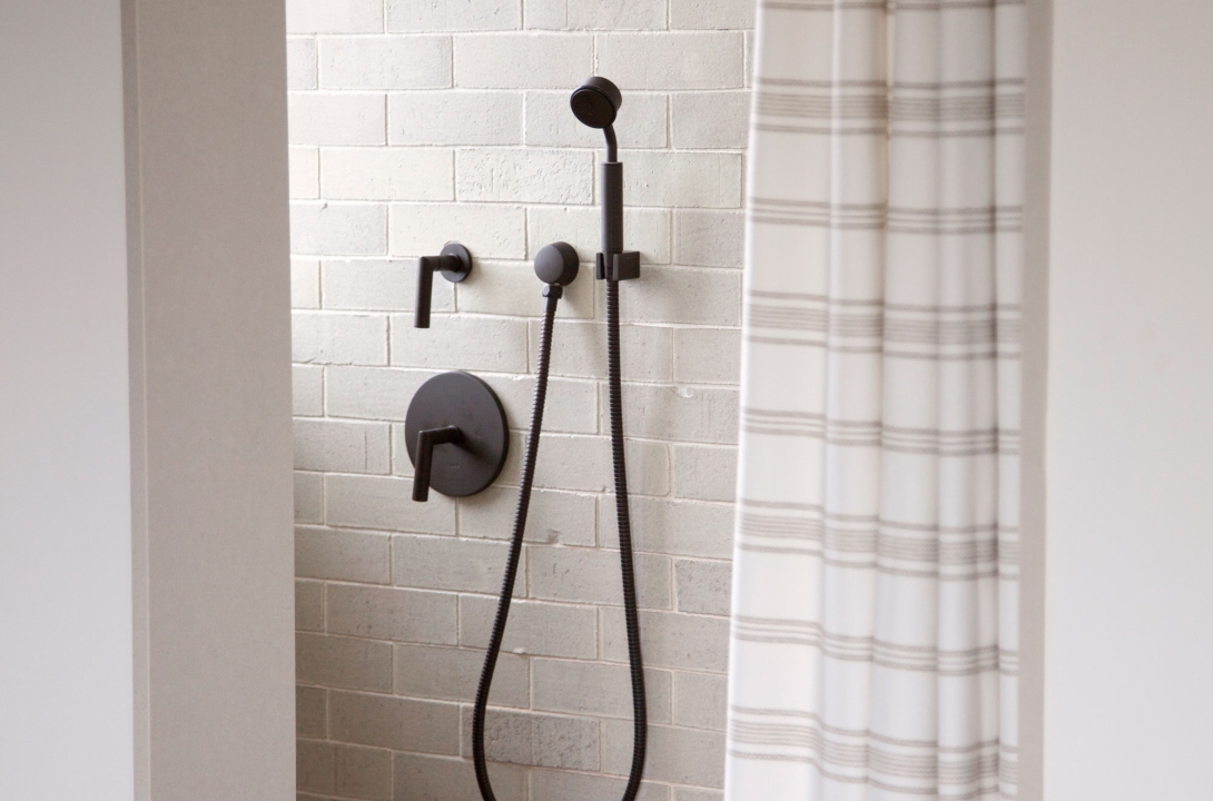 A treatment room bathroom with a shower head and curtain.